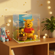 LEGO Winnie the pooh character in a custom display case with cloudy background on a wooden surface.