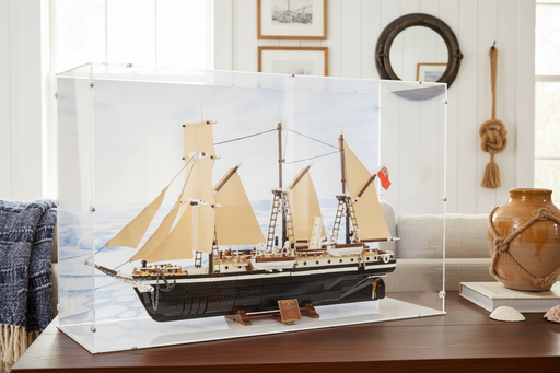 historic lego toy ship in a display case on a wooden surface with decorative items in the background.