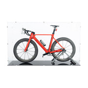 A red road bicycle made from lego, displayed inside a clear acrylic case against a black glossy floor.