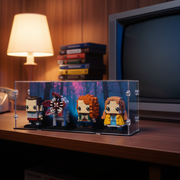 brickheadz lego figures in a display case on a wooden desk with a lamp and vintage TV in the background.