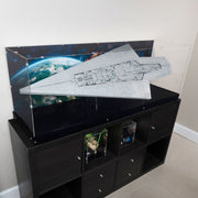 A large clear acrylic display case holding the lego star wars 75457 set, on top of a black storage cabinet in an indoor room with a mural showing Endor space.