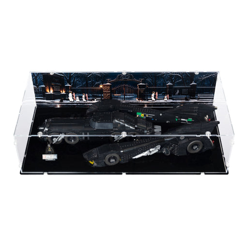 A black LEGO-style Batmissile model set inside a clear acrylic display case with a dark illustrated backdrop