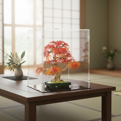 Bonsai tree lego set in a clear display case on a wooden table with a blurred indoor background.