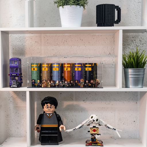 Shelf with LEGO Harry Potter-themed figurines in a display case, books, and a mug on a concrete wall background.
