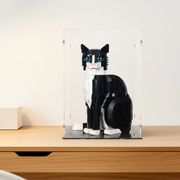 Black and white cat-shaped lego model in a clear display case on a wooden surface.