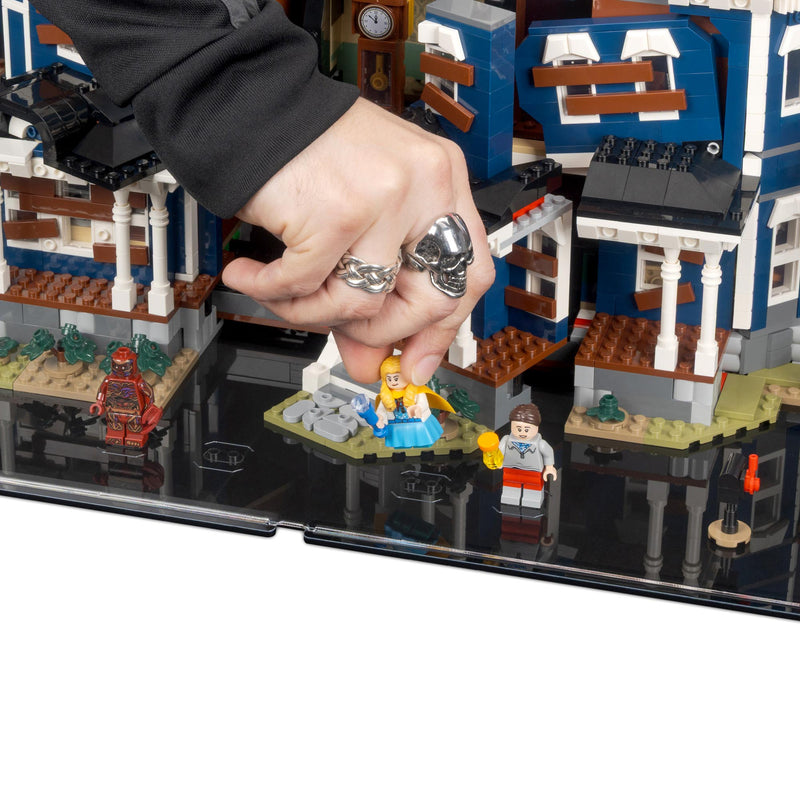 Hand placing a LEGO figure on a detailed LEGO city street scene.